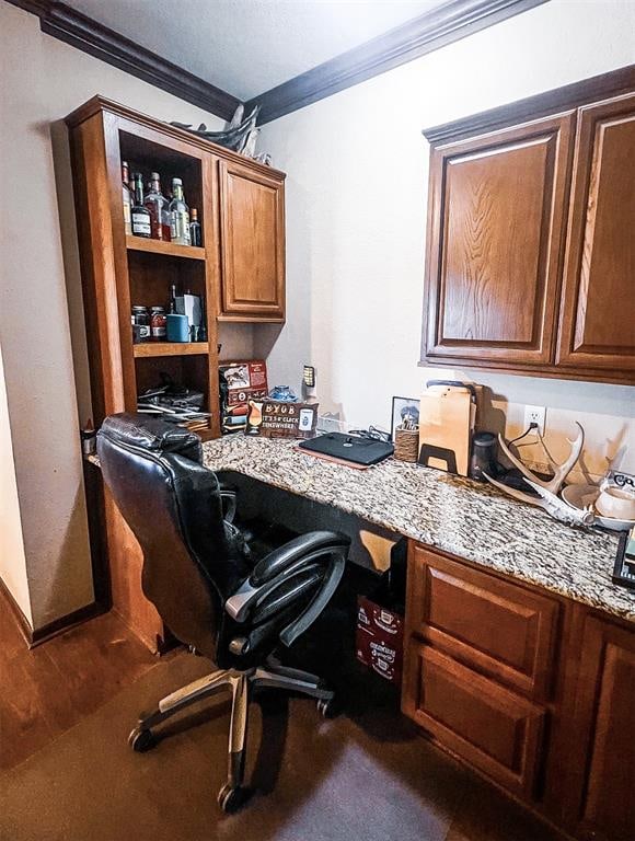 office area featuring dark wood-type flooring, built in desk, and ornamental molding