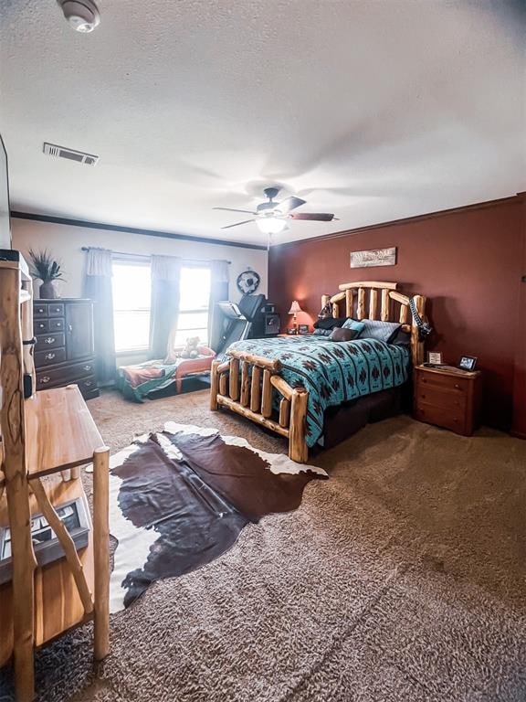 carpeted bedroom featuring ceiling fan, ornamental molding, and a textured ceiling