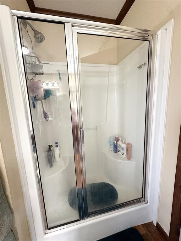 bathroom with wood-type flooring and a shower with shower door