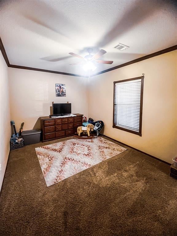 carpeted bedroom with a textured ceiling, ceiling fan, and crown molding