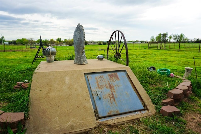 entry to storm shelter with a yard and a rural view