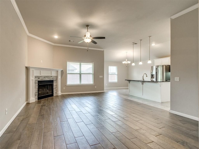 2213 Waterbrook Ct, Norman, OK 73026 - unfurnished living room featuring crown molding, a ceiling fan, wood finished floors, a sink, and baseboards