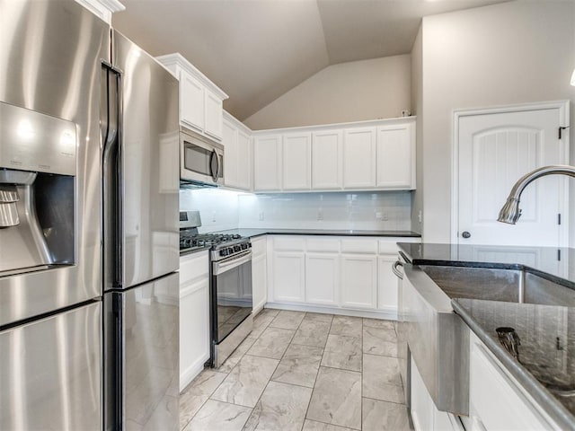 2213 Waterbrook Ct, Norman, OK 73026 - kitchen with appliances with stainless steel finishes, vaulted ceiling, a sink, light marble finish floors, and dark stone counters