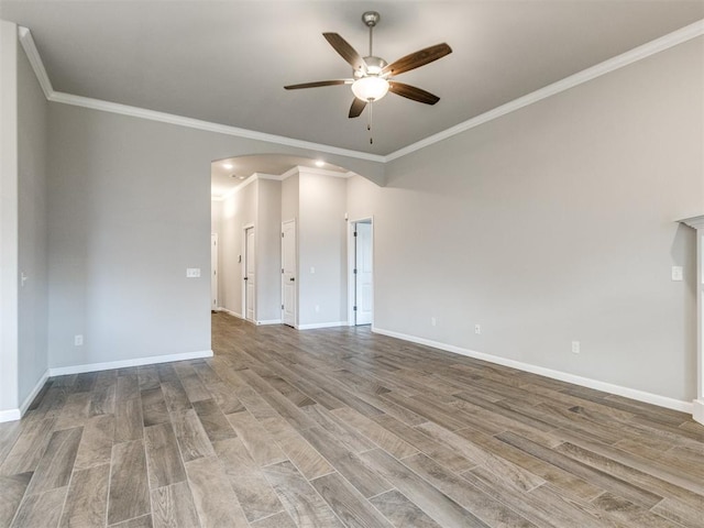 2213 Waterbrook Ct, Norman, OK 73026 - empty room with arched walkways, a ceiling fan, wood finished floors, crown molding, and baseboards