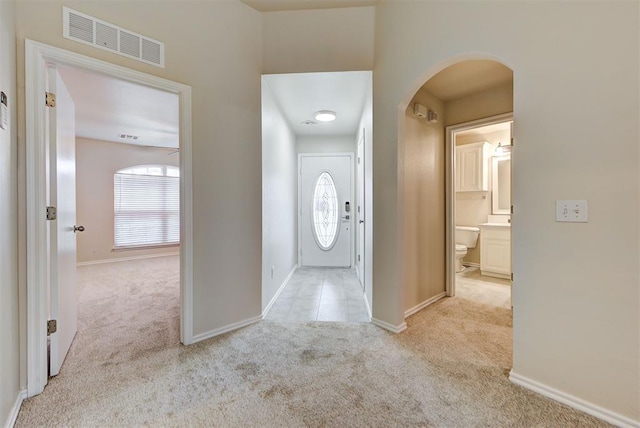 hallway with plenty of natural light and light colored carpet