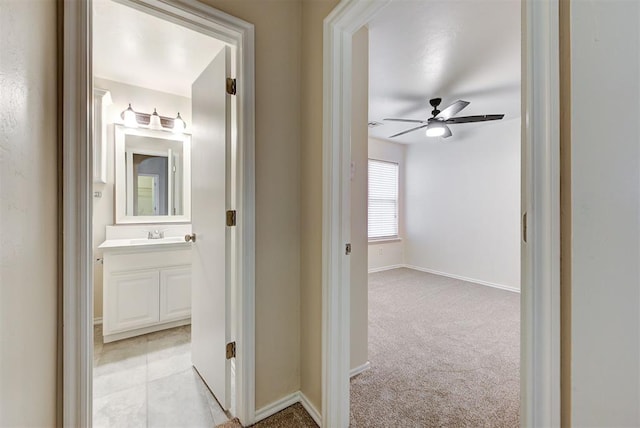 hall featuring light carpet and sink