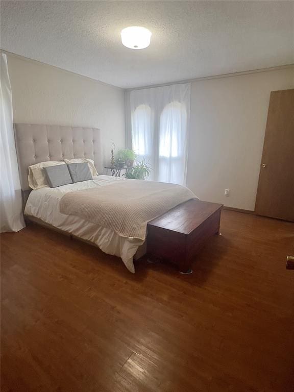 bedroom with a textured ceiling and dark wood-type flooring