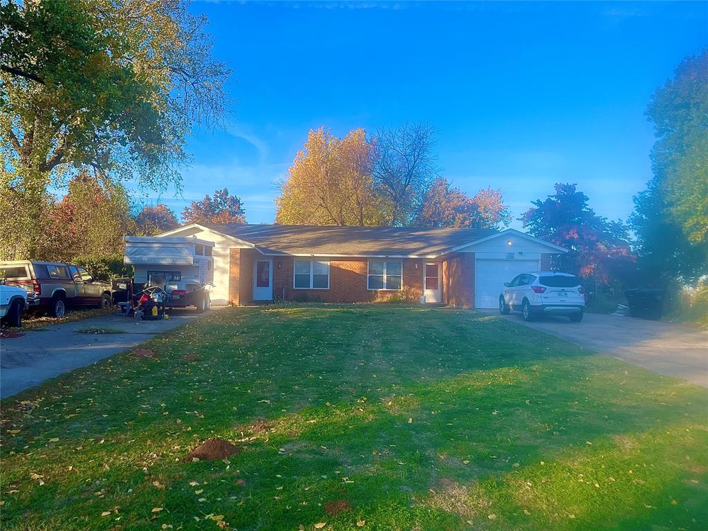 ranch-style house with a garage and a front lawn