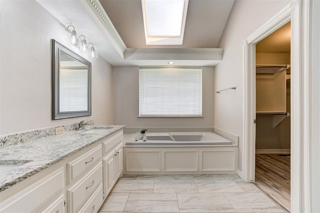 bathroom with hardwood / wood-style flooring, vanity, a healthy amount of sunlight, and a tub