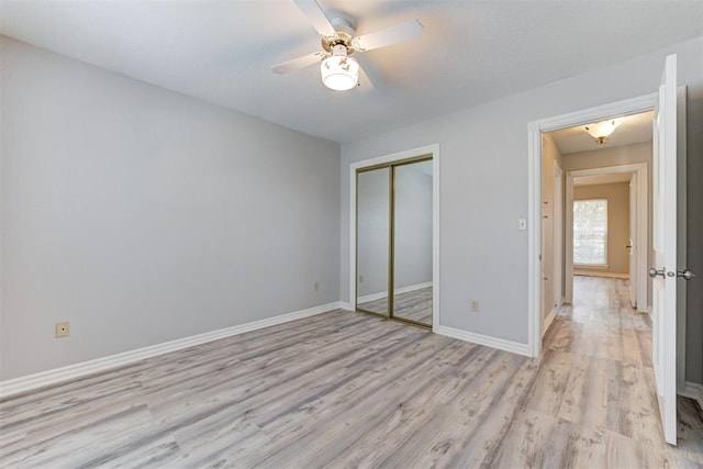 unfurnished bedroom featuring ceiling fan, light hardwood / wood-style floors, and a closet