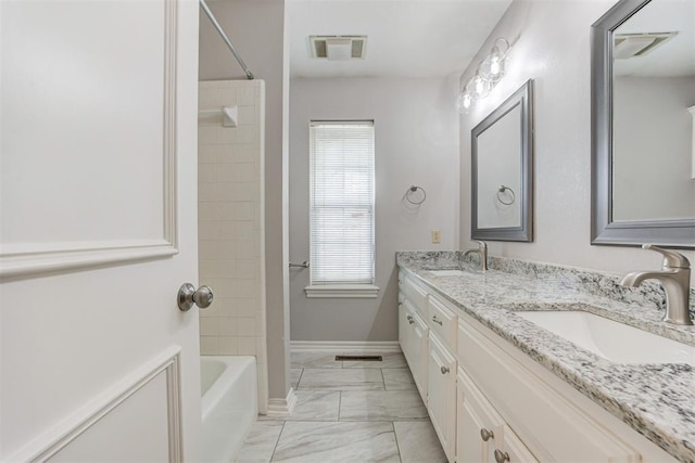 bathroom with vanity and tiled shower / bath