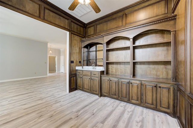 bar with light hardwood / wood-style floors, ceiling fan, crown molding, and sink