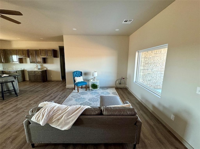 living room featuring ceiling fan and dark hardwood / wood-style floors