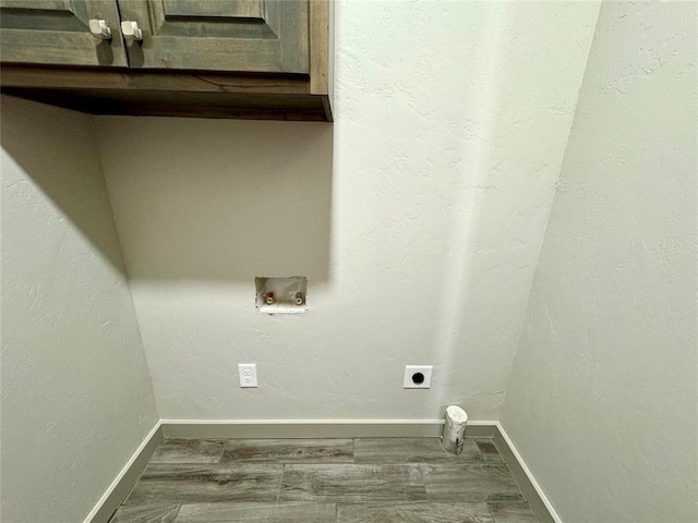 clothes washing area with hookup for an electric dryer, cabinets, wood-type flooring, and hookup for a washing machine