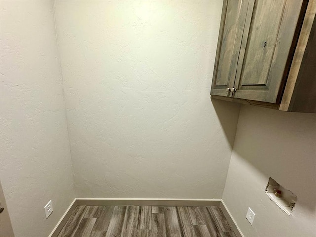 laundry room with washer hookup, cabinets, and hardwood / wood-style flooring