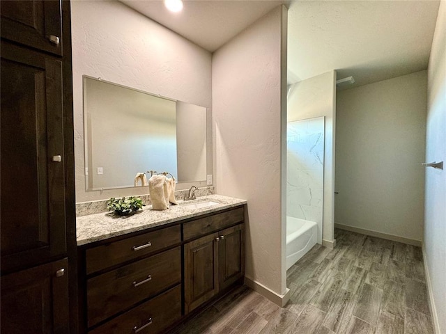 bathroom featuring hardwood / wood-style flooring, vanity, and shower / bathtub combination