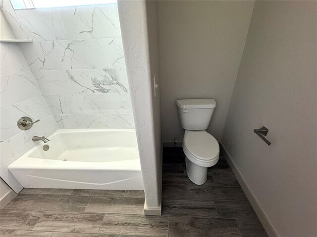 bathroom with hardwood / wood-style floors, a bathtub, and toilet