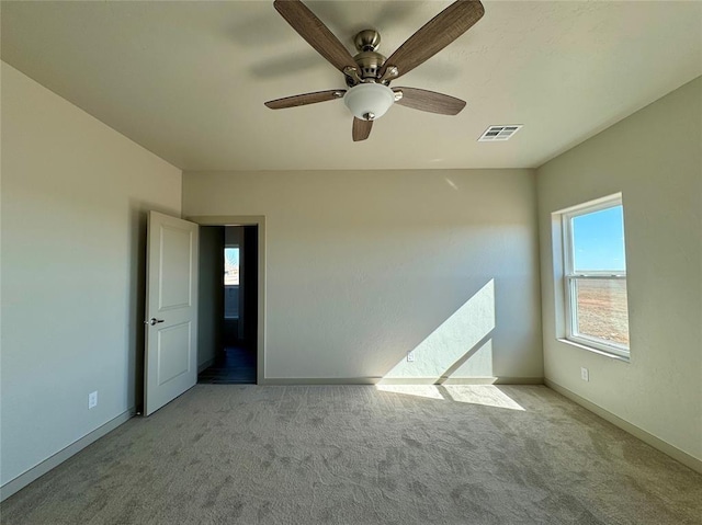 carpeted spare room with ceiling fan