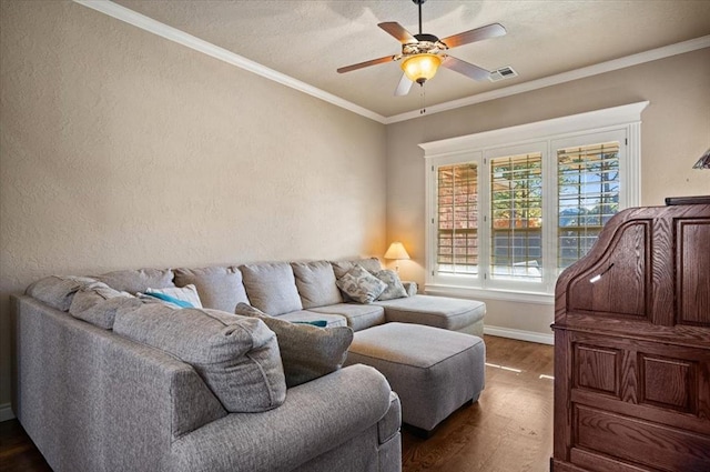 living room with dark wood-type flooring, ceiling fan, and crown molding