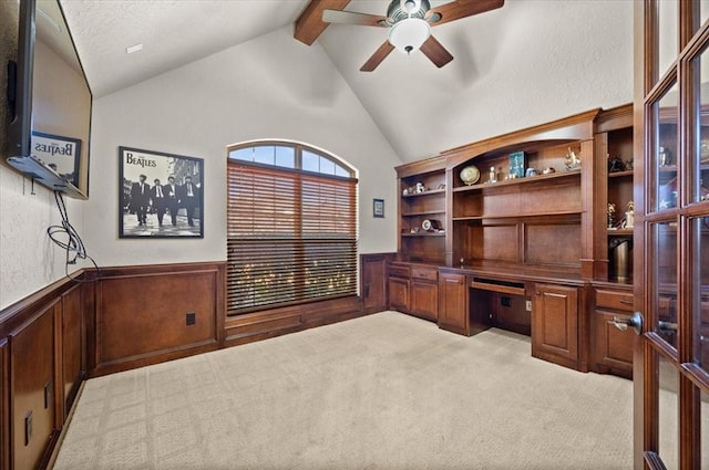 office space with built in desk, light colored carpet, lofted ceiling with beams, a textured ceiling, and ceiling fan