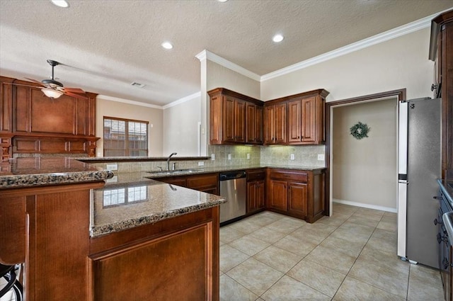 kitchen featuring sink, dark stone countertops, kitchen peninsula, stainless steel appliances, and a textured ceiling