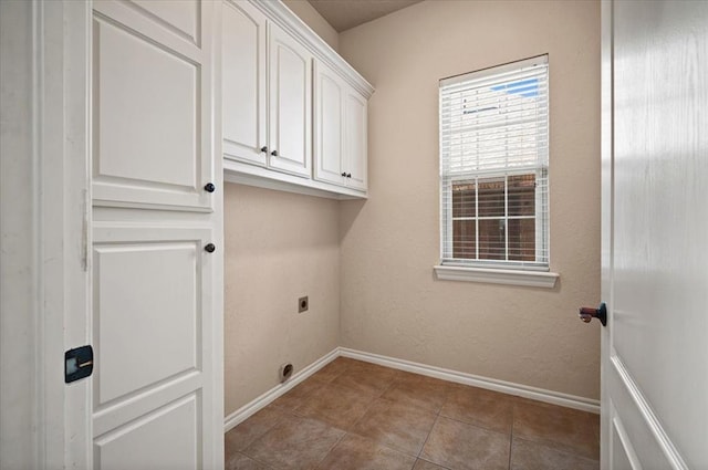 washroom featuring cabinets, hookup for an electric dryer, and light tile patterned floors