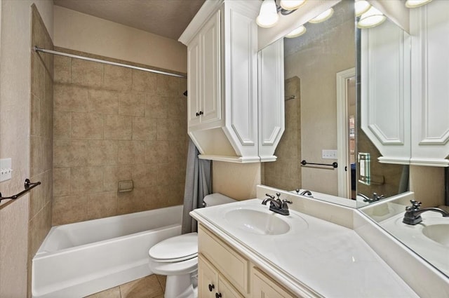 full bathroom with tile patterned flooring, vanity, tiled shower / bath combo, and toilet