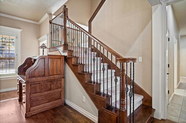 stairs with hardwood / wood-style flooring and ornamental molding