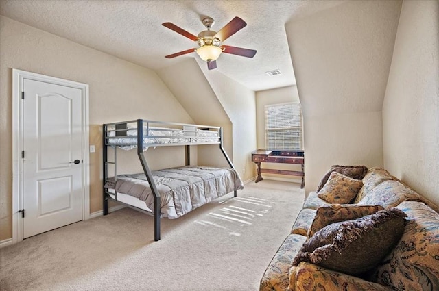 carpeted bedroom featuring ceiling fan, vaulted ceiling, and a textured ceiling