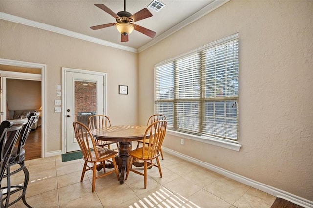 dining room with a healthy amount of sunlight, light tile patterned floors, crown molding, and ceiling fan