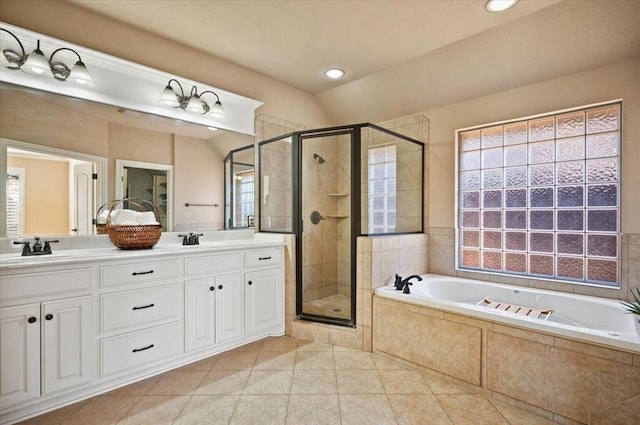 full bathroom with double vanity, a stall shower, a garden tub, and a sink