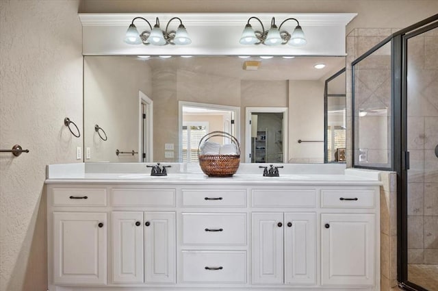 bathroom featuring a sink, a shower stall, and double vanity