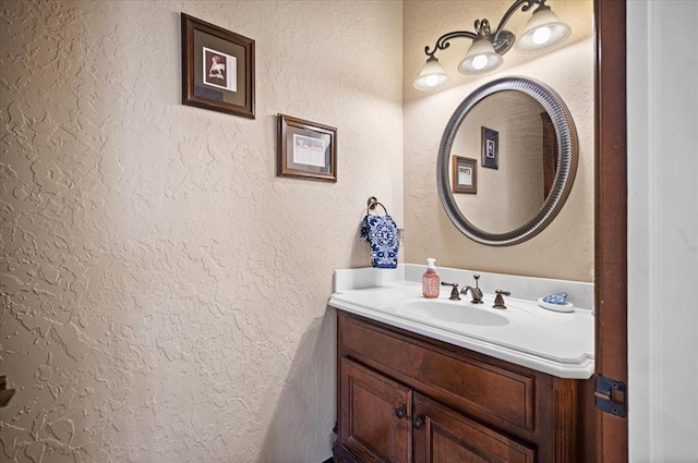 bathroom featuring a textured wall and vanity