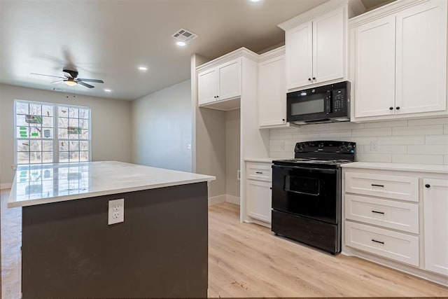 kitchen featuring white cabinets, black appliances, a center island, backsplash, and light wood-type flooring