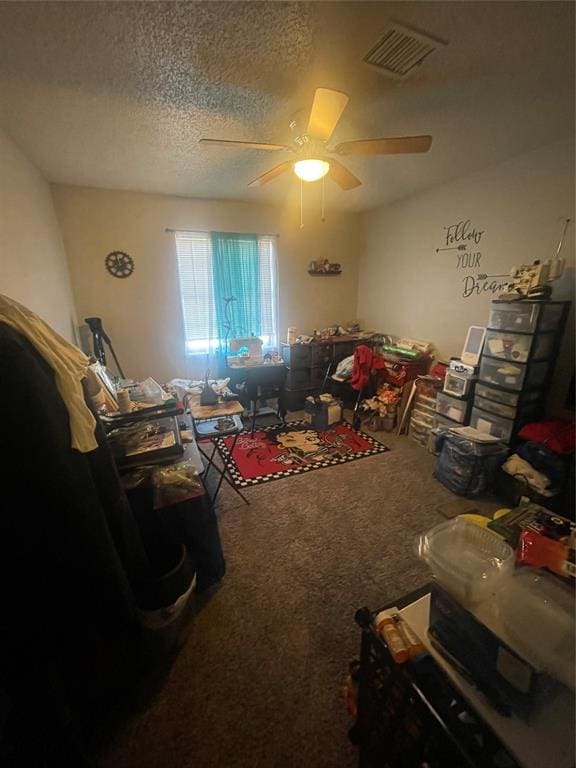 interior space with a textured ceiling and ceiling fan