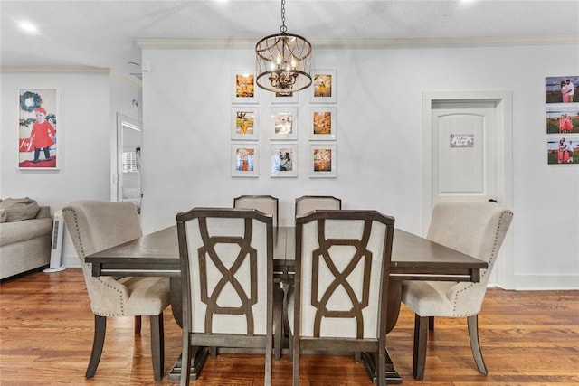 dining area featuring crown molding, hardwood / wood-style floors, and a notable chandelier