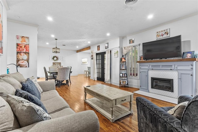 living room with a fireplace, wood-type flooring, and crown molding