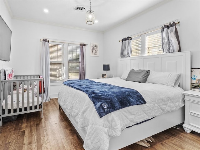 bedroom featuring crown molding, dark wood-type flooring, and multiple windows