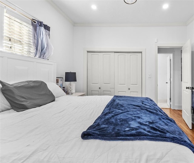 bedroom featuring crown molding, a closet, and hardwood / wood-style flooring