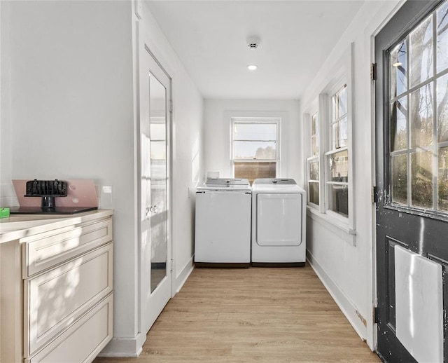 laundry room with independent washer and dryer and light hardwood / wood-style floors