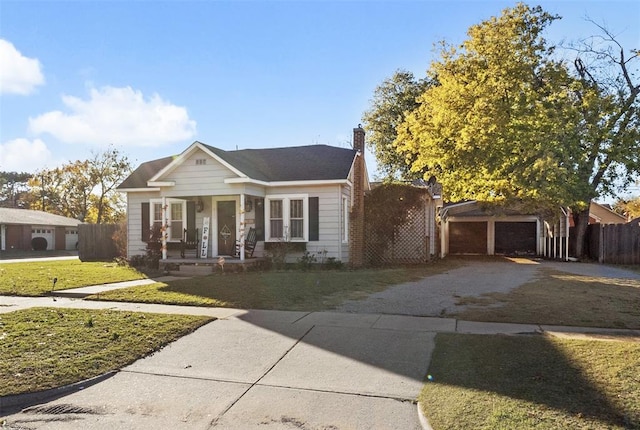 bungalow-style house with a porch, a garage, and a front lawn