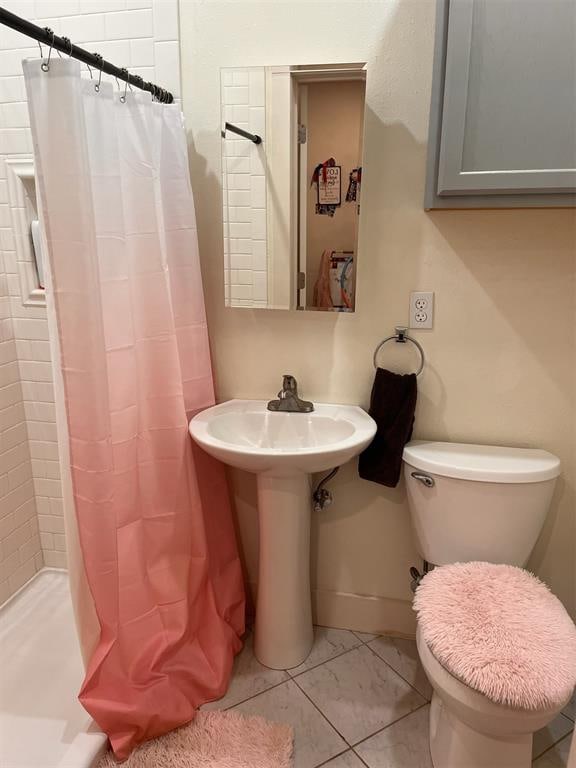 bathroom with tile patterned floors, toilet, and a shower with shower curtain