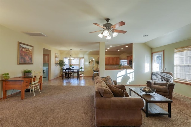 living room featuring vaulted ceiling, ceiling fan, sink, washer / dryer, and carpet floors