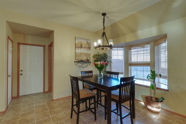 dining space with tile patterned flooring and a chandelier