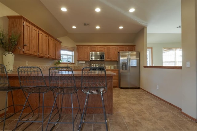 kitchen featuring a breakfast bar, sink, kitchen peninsula, and stainless steel appliances