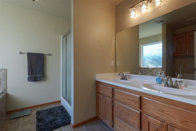 bathroom featuring tile patterned flooring, vanity, and an enclosed shower