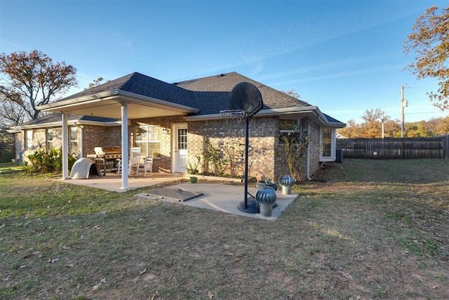 back of house with a yard and a patio