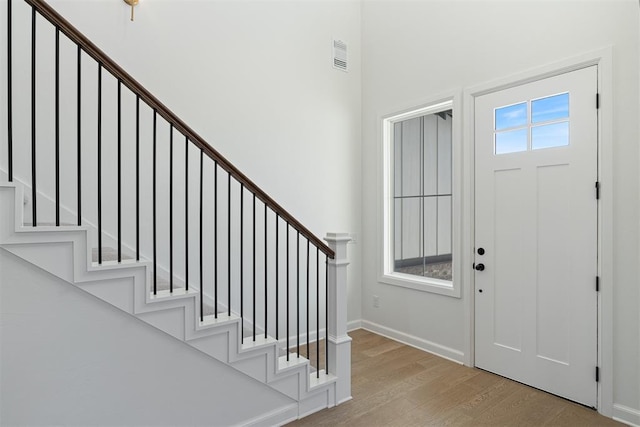 entrance foyer featuring visible vents, stairs, and wood finished floors