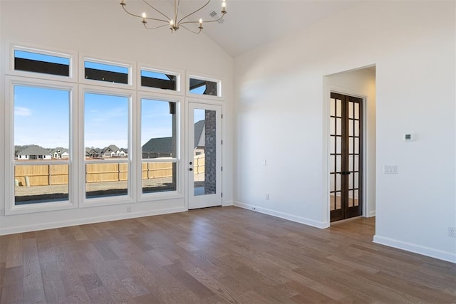 417 Basin Way, Norman, OK 73069 - spare room with a chandelier, dark wood finished floors, baseboards, and high vaulted ceiling