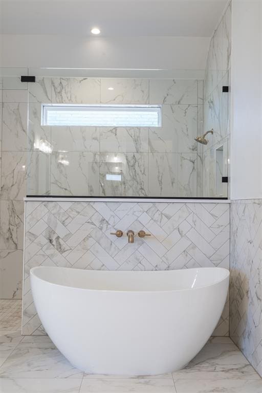 417 Basin Way, Norman, OK 73069 - bathroom with a soaking tub, marble tiled floors, a marble finish shower, and tile walls